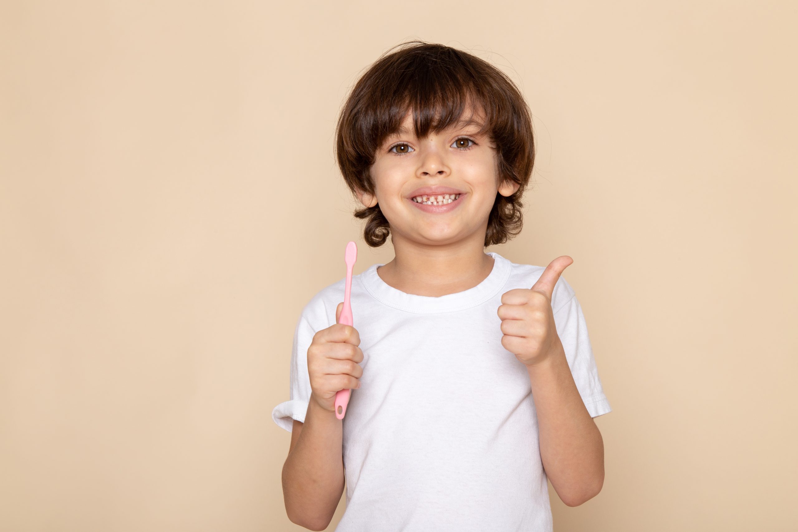 front-portrait-view-smiling-boy-cute-adorable-sweet-white-t-shirt-pink-wall