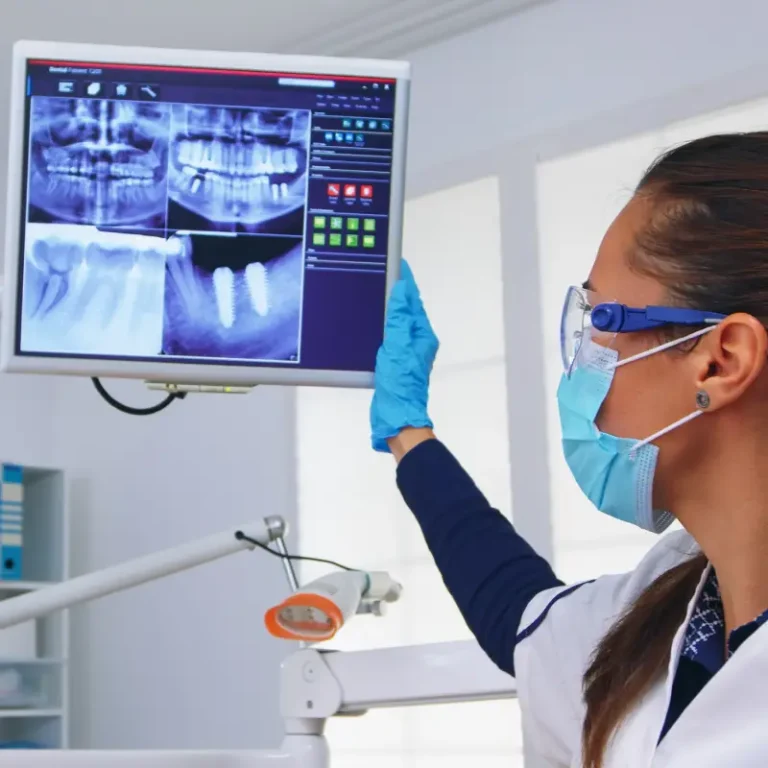 Dental team member reviewing digital X-rays on a screen in the treatment room